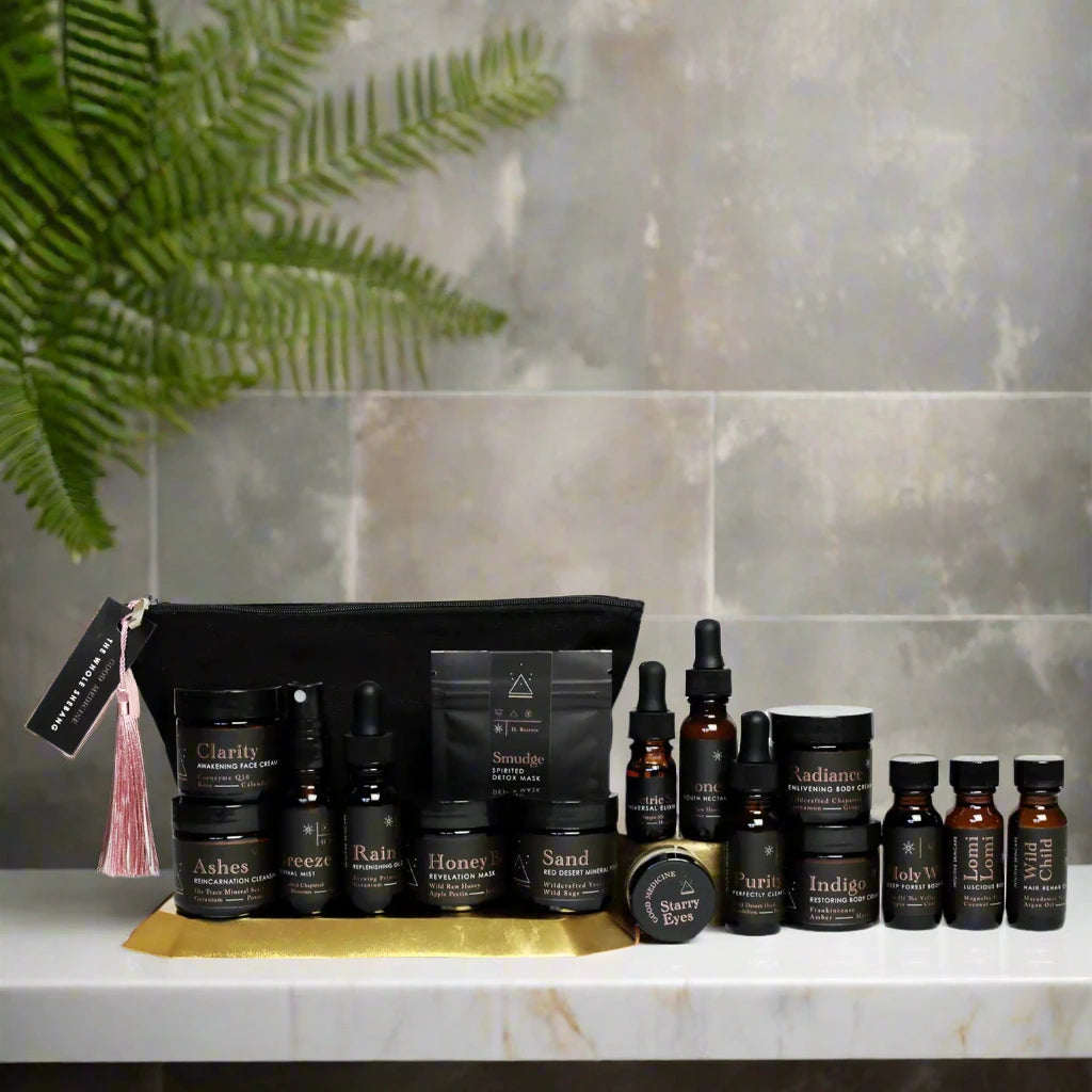 all product bottles displayed in front of the case on a marble bathtub with fern plant in the upper left corner