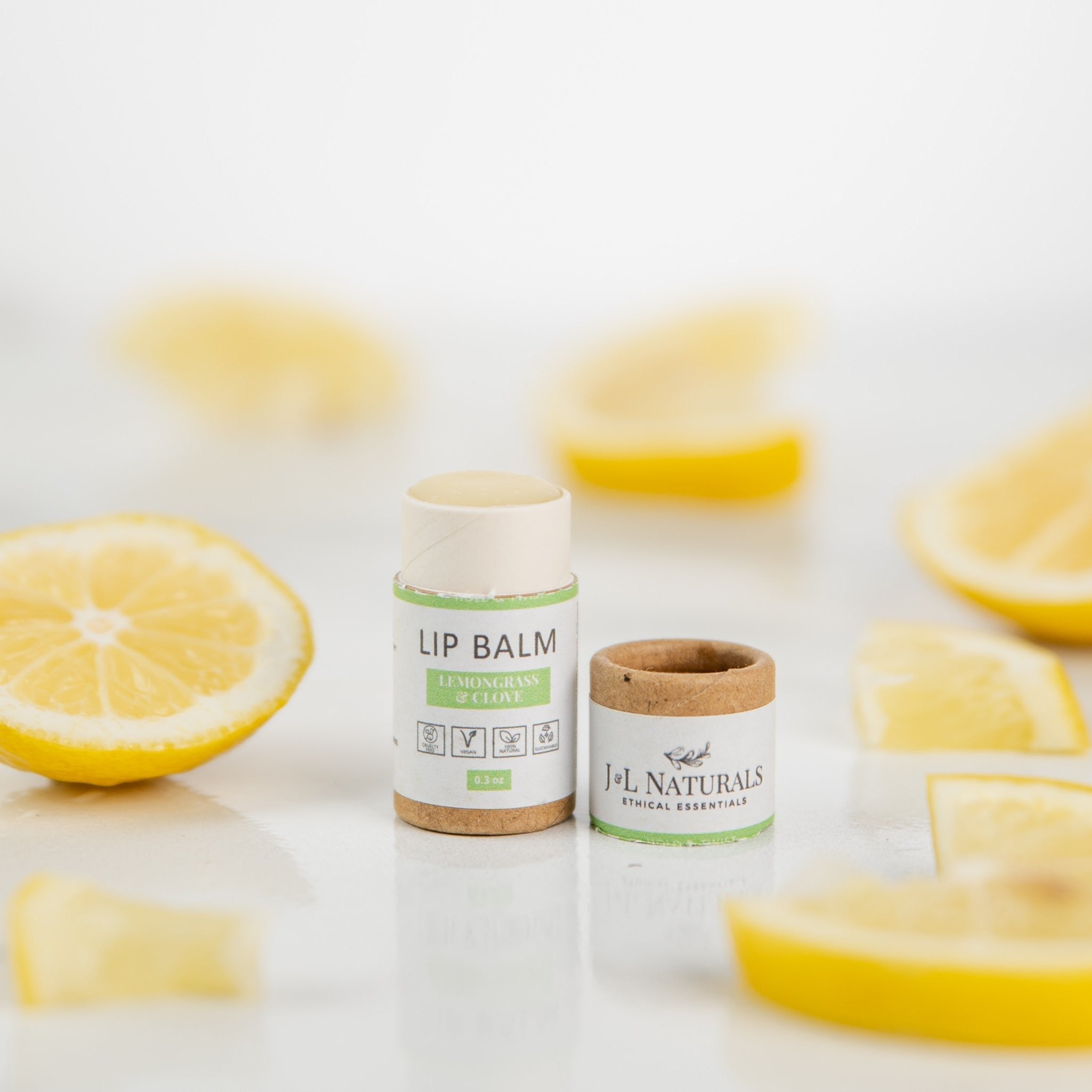 Lip balm sticks displayed with sliced lemons and mint leaves for a refreshing look.