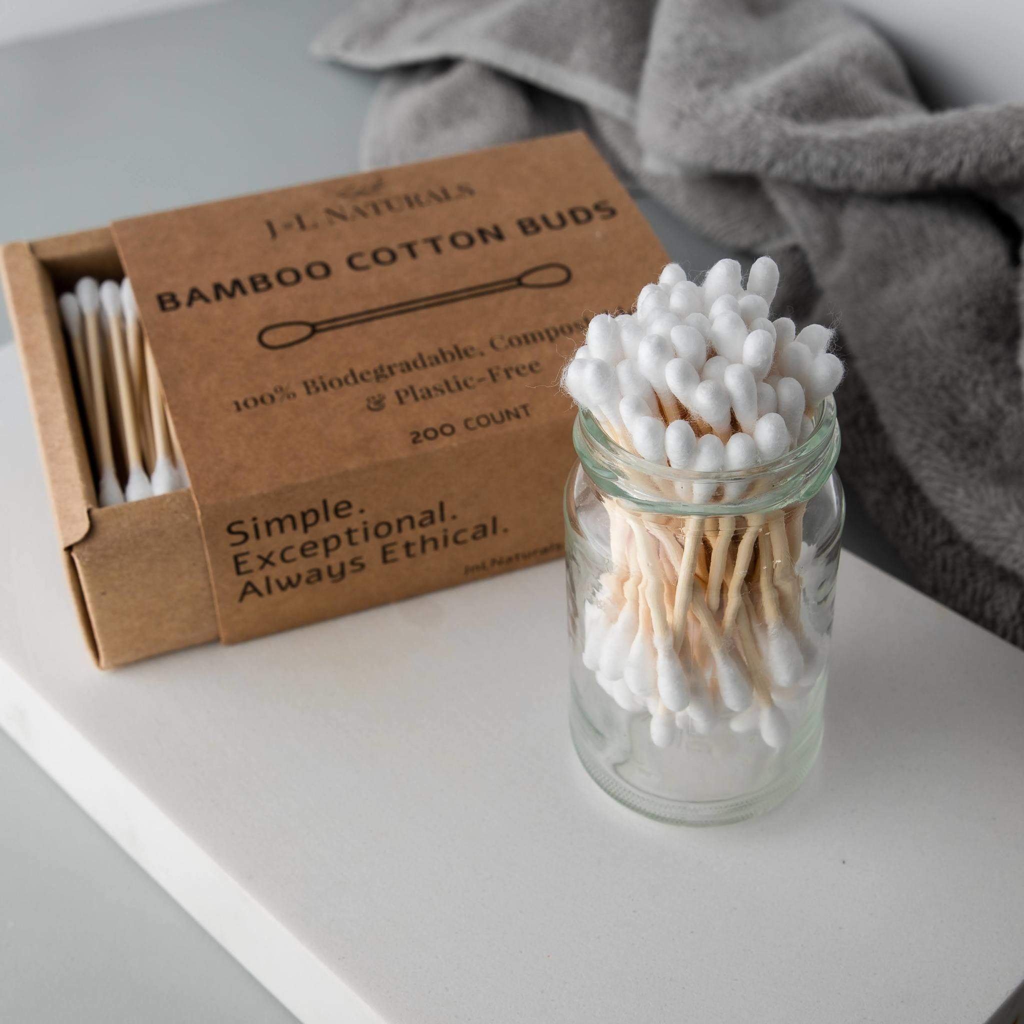 jar of swabs next to an open box of them on a white shelf with grey towel