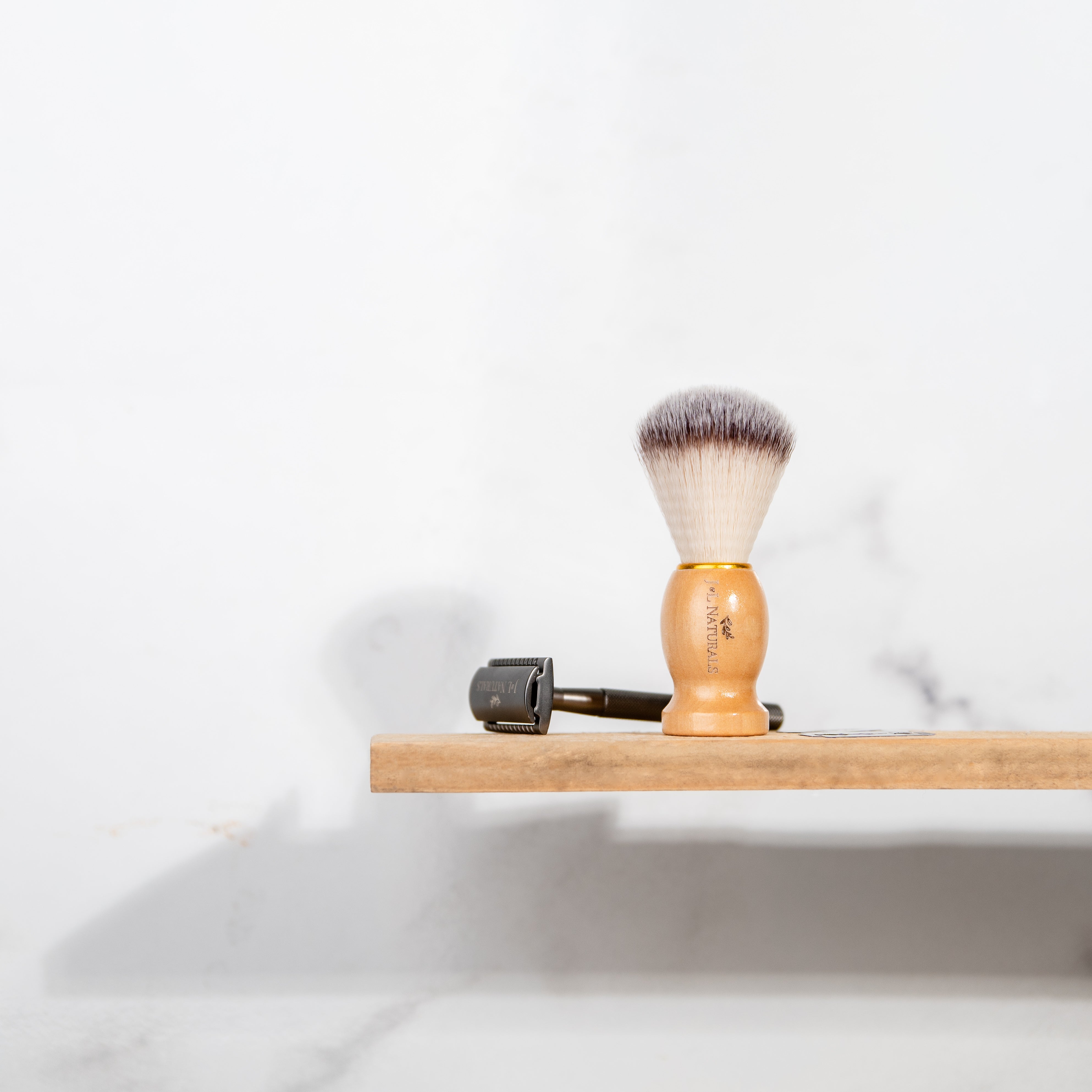 shave brush and razor on wood shelf with white background