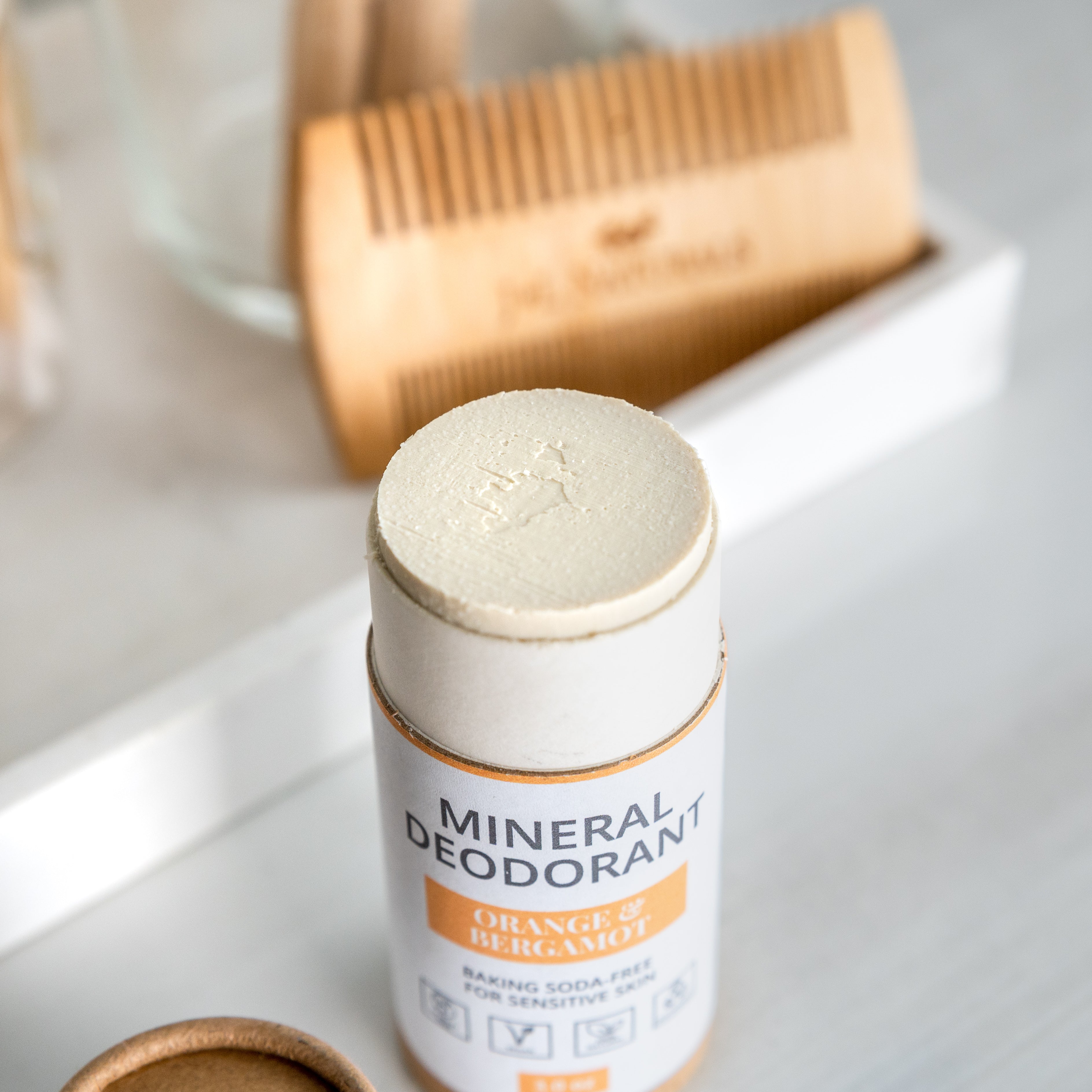 Mineral Deodorant on a bathroom counter with a wooden comb and towel, promoting a clean and sustainable self-care routine.