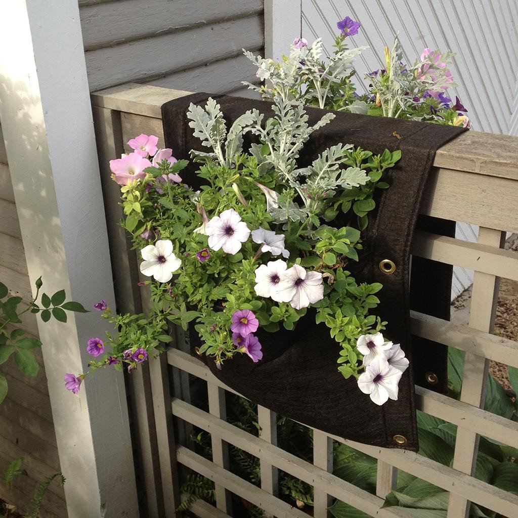 planter draped over railing, it has flowers growing on both sides